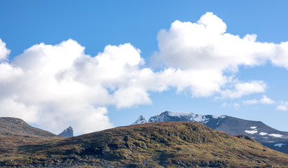 Mountain scenery with snow on the high peaks against blue sky background