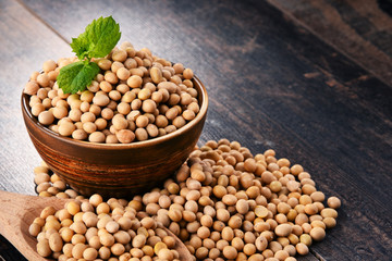 Composition with bowl of soya beans on wooden table