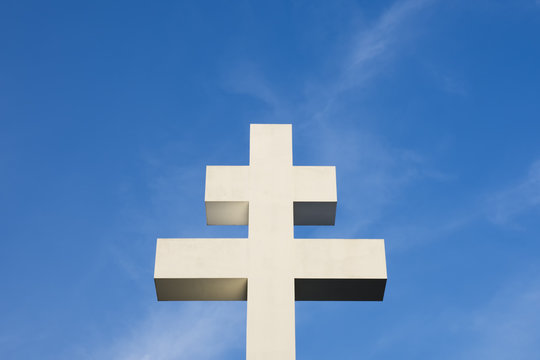 Photo of a large white double cross on a blue sky