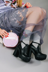 Female legs wearing shoes over grey background