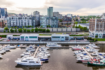 Aerial view of old port area with many boats and downtown in city in Quebec region during sunset