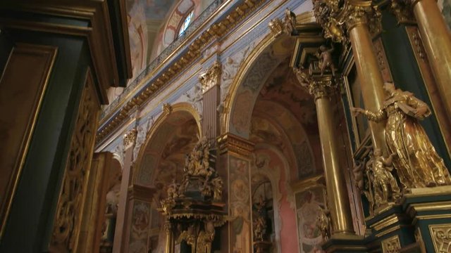 Beautiful Bernardine church interior. Golden sculptures and religious frescoes.
