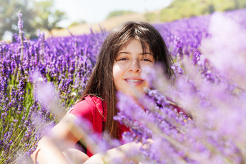 Romantic girl sitting in lavender meadow