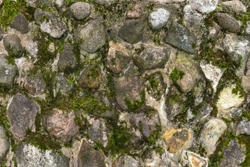 Old wall of stones covered with moss