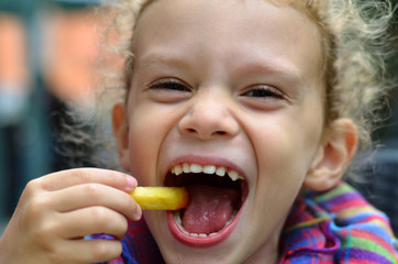 Kind isst fröhlich Pommes Fastfood