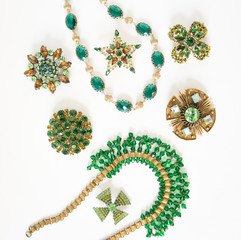 Woman's Jewelry. Vintage jewelry background. Beautiful bright rhinestone brooches, braceletes, necklace and earrings on white. Flat lay, top view