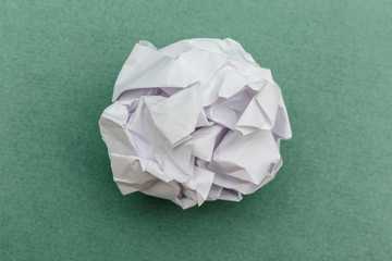 wad of crumpled paper on green background