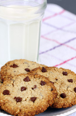 refreshment, eating snack: glass of milk and chocolate chip cookies on table cloth with copy space