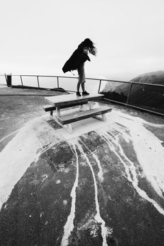A girl standing on a table in the wild wind