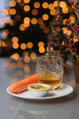 Mince pie, carrot and glass of whiskey left on a plate on Christmas Eve for Santa Claus and Rudolph