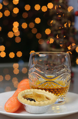 Mince pie, carrot and whiskey left on a plate on Christmas Eve for Santa Claus and Rudolph