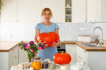Woman in kitchen with pumpkins 