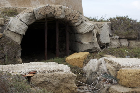 Entrata e uscita di un nascondiglio nascosto sotto una torre e protetto da grate di ferro.