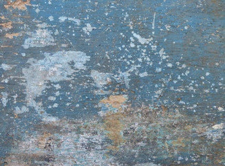 Old wooden board painted in blue, with cracks and random white spots