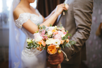 Obraz na płótnie Canvas Bride's bouquet. Newlyweds on background