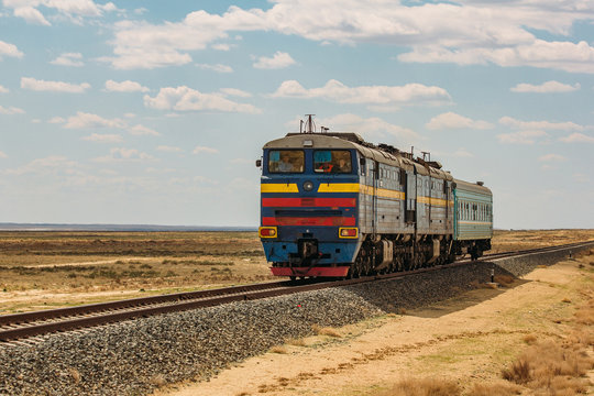 Fototapeta Locomotive train is passing through desert