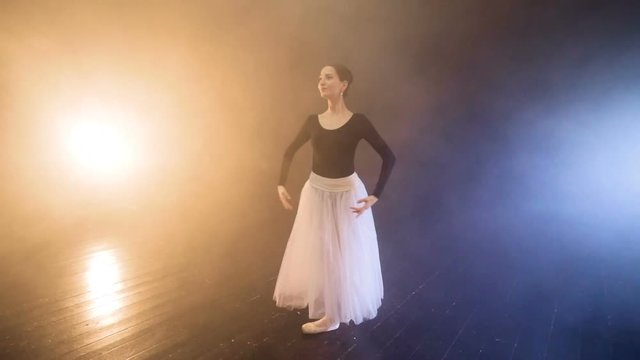 A ballerina bows and gets up on a stage. 