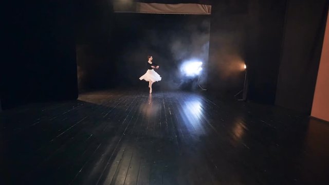 A zoomed up ballet dancer finishing up her performance with a bow. 