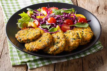 Vegetarian Food: Quinoa fritters with spinach, carrots and salad of fresh vegetables close-up. horizontal