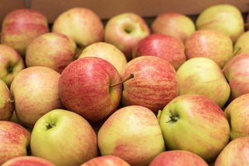 Beautiful appetizing fruit background with apples in a cardboard box