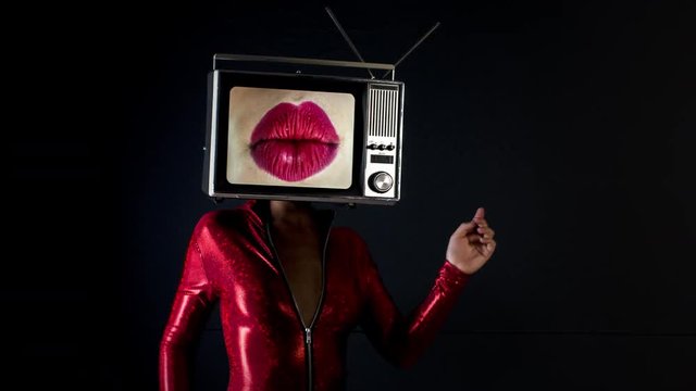 amazing woman dancing and posing with a television as a head. the tv has video of moving luscious lips on it