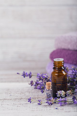 Fototapeta na wymiar Bottle of essential oil and fresh lavender flowers