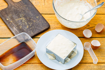Photo of wooden table with tiramisu dessert in metal form