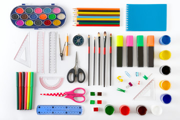 Fototapeta premium Set of school supplies on white background. Paint, pencils, notepad, brushes, scissors.