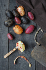 Fresh colorful potatoes on the dark wooden table