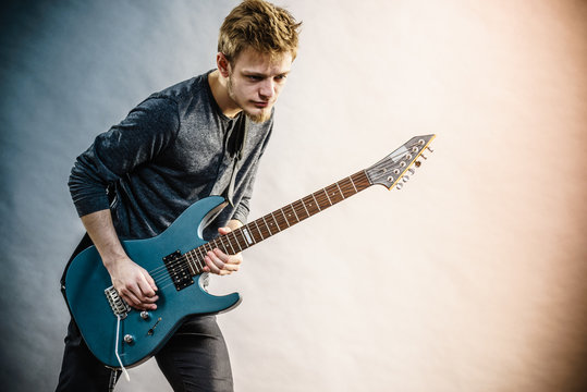 Young man playing electric guitar