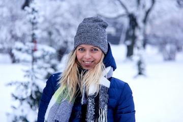 Beautiful winter portrait of young woman in the winter snowy scenery. Beautiful girl in winter clothes. Young woman portrait. beauty girl on the blurred background