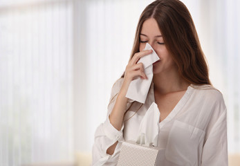 Young beautiful woman, teenage girl Sneezing into Tissue. Flu, Allergy, Runny Nose