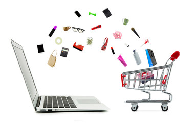 Shopping cart and laptop computer with products isolated on white background, shop online concept.