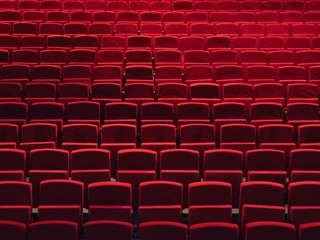 Rangées de fauteuils rouges dans une salle de spectacle