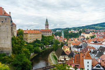Fototapeta na wymiar Krumlov Castle and the Czech Krumlov. Medieval fortress and the river Vltava. Red roof tiles and narrow streets. Houses made of stone.