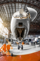 A large passenger aircraft on the service in the aviation hangar view the nose and radar under the hood, the front chassis riser. © aapsky