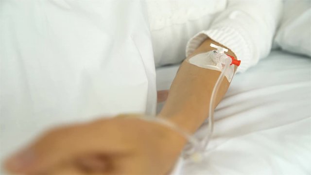 A young female patient in a hospital ward with a drip