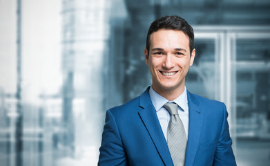 Smiling businessman in front of a blue background