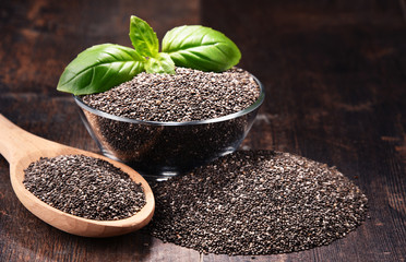 Composition with bowl of chia seeds on wooden table