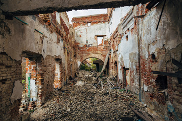 Fototapeta na wymiar Ruined red brick industrial building. Abandoned and destroyed sugar factory in Novopokrovka, Tambov region