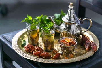 Foto auf Acrylglas Marokkanischer Mn-Tee in traditionellen Gläsern mit Minze, Datteln und Zucker © fazeful