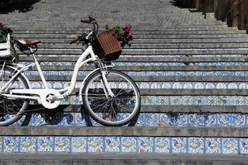 Bicycle on stairway with steps made of ceramic tiles in the town famous of pottery production - Caltagirone (Caltaggiruni), Sicily, Italy