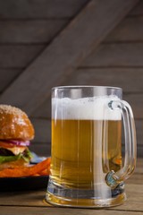 Burger and french fries in plate with glass of beer