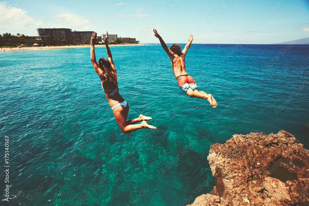 Wall mural friends cliff jumping into the ocean