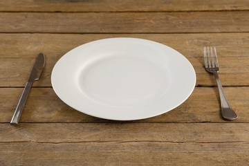 White plate with cutlery on table