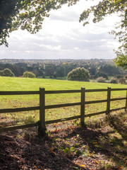 country side open rolling fields below with wooden fence up front