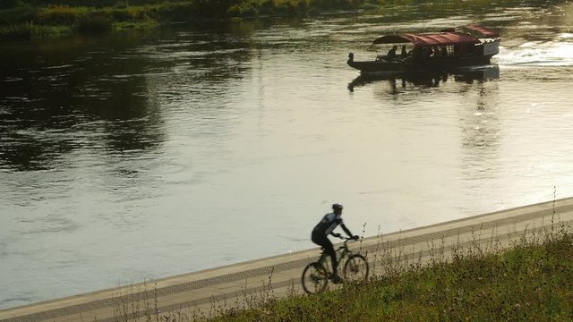 Canal scene with narrowboat whit tourists and cyclists on the shore.