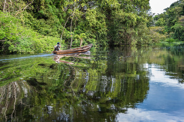 Amazonian man boating in canoe up the Nauta Cano river