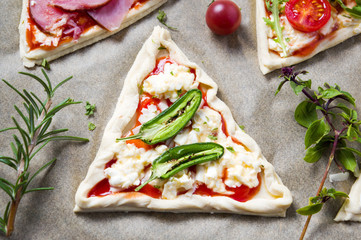 Pastry sandwiches with vegetables on baking paper