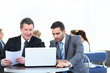 business partners discussing a new project, sitting in the lobby of the office.